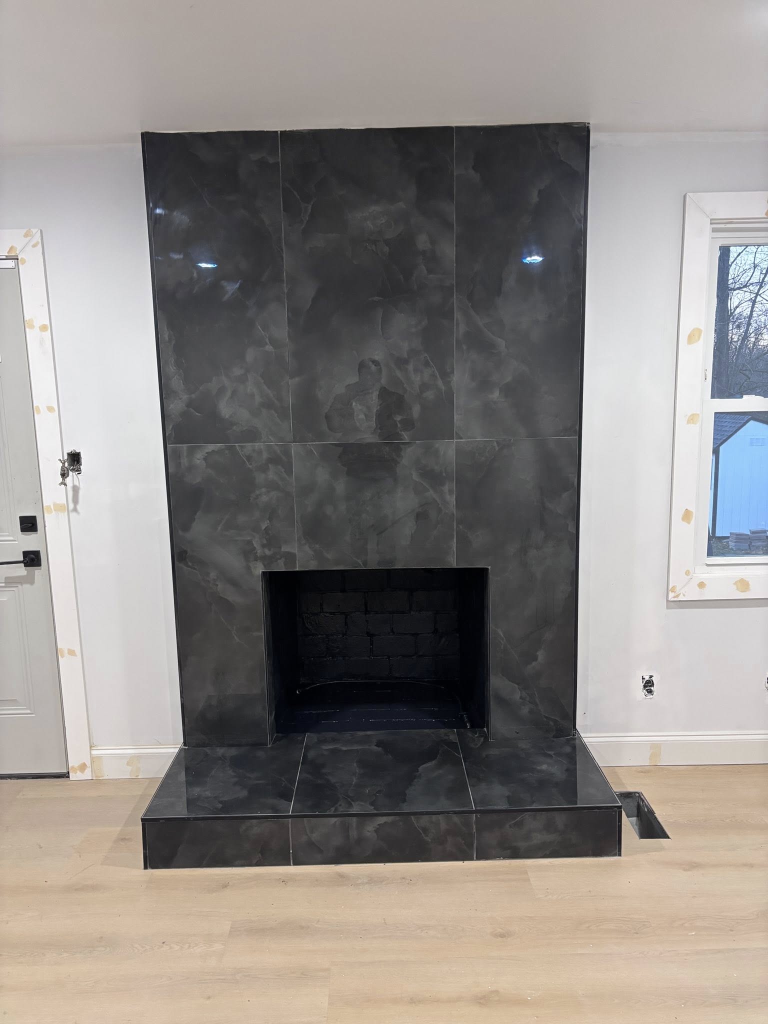 Custom black marble tile fireplace remodel by Grandson's Remodeling